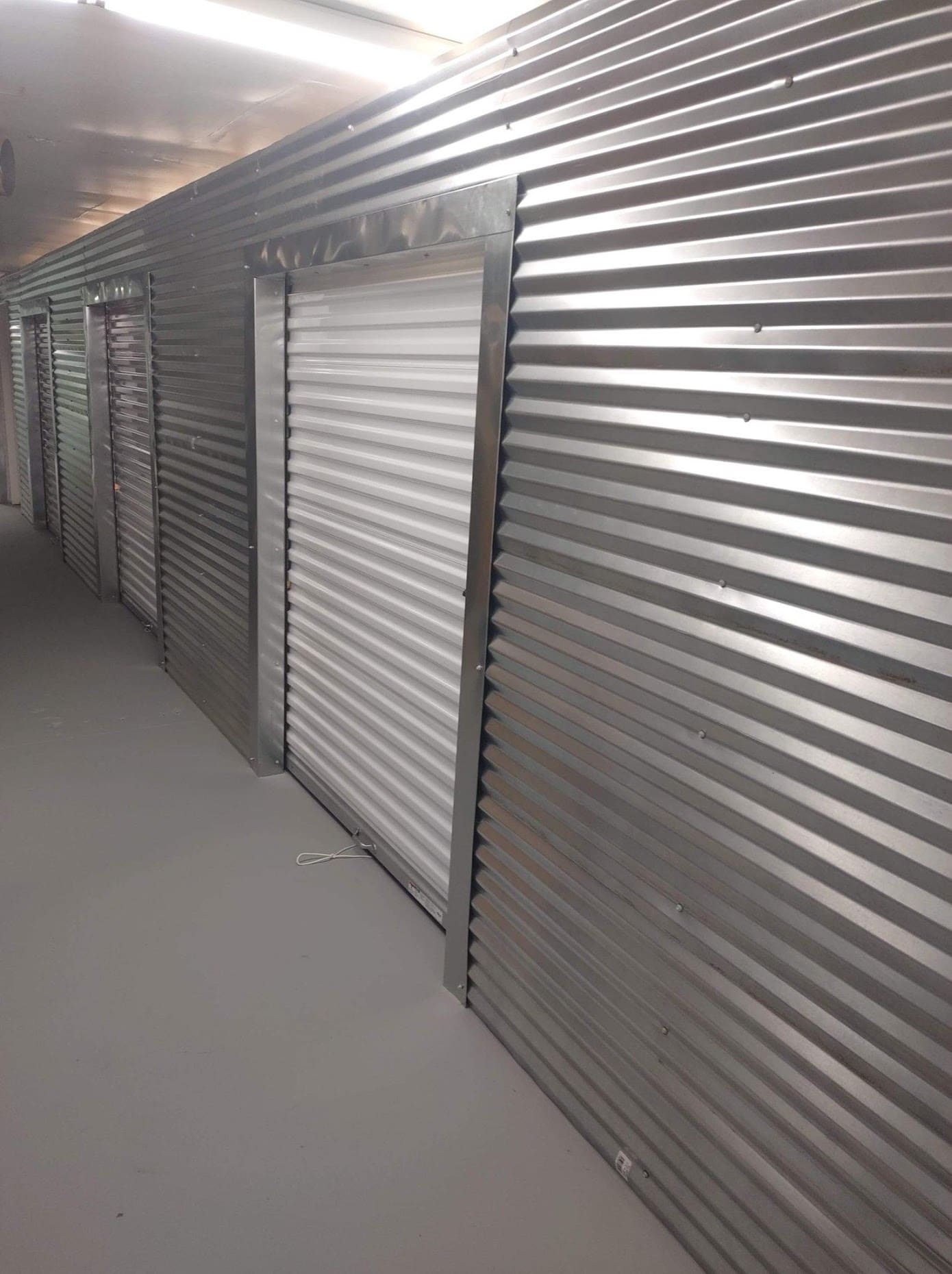 Metal storage units with corrugated steel doors in indoor facility